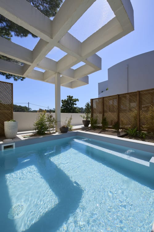 Piscina contemporânea com spa na Casa Redonda by Villas Aura, Aroeira Portugal, com pérgula branca e tela de privacidade