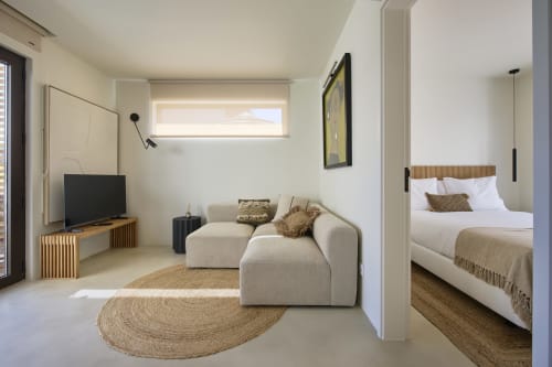 Moderno estúdio em Casa Redonda com sofá creme, TV, quarto e vista para piscina da villa Aroeira