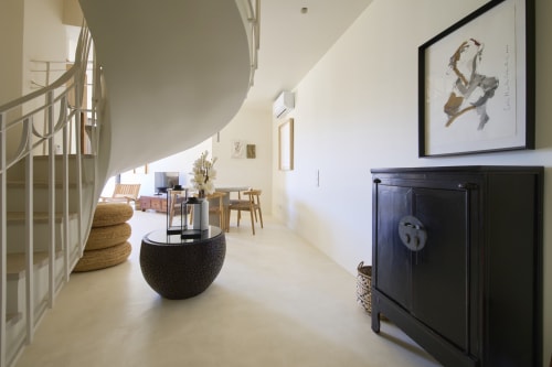 Modern loft apartment at Casa Redonda, Aroeira with spiral stairs, round black table, and minimalist decor