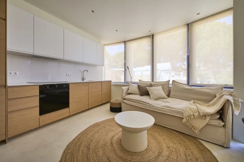 Modern open-plan apartment at Casa Redonda, Aroeira with kitchen, sofa, and garden views