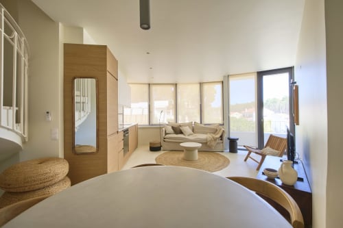Modern studio apartment at Casa Redonda, Aroeira with open-plan living, wooden accents, natural light, and garden views