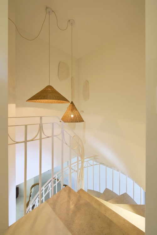 Modern stairwell at Casa Redonda with woven pendant lights and white railings, Aroeira Portugal