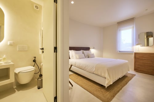 Modern bedroom at Casa Redonda, Aroeira with ensuite bathroom, queen bed, and garden views