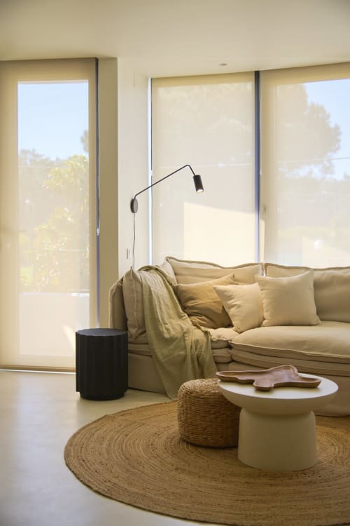 Modern living area at Casa Redonda by Villas Aura in Aroeira with cream sofa, natural light, and pool view through large