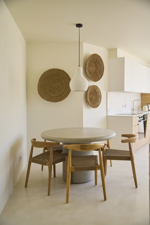 Modern dining area with round table and wooden chairs at Casa Redonda, Aroeira Portugal apartment