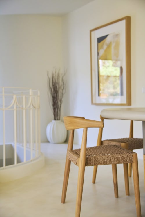 Modern apartment interior at Casa Redonda, Aroeira with wooden chair, desk, framed artwork, and white decor