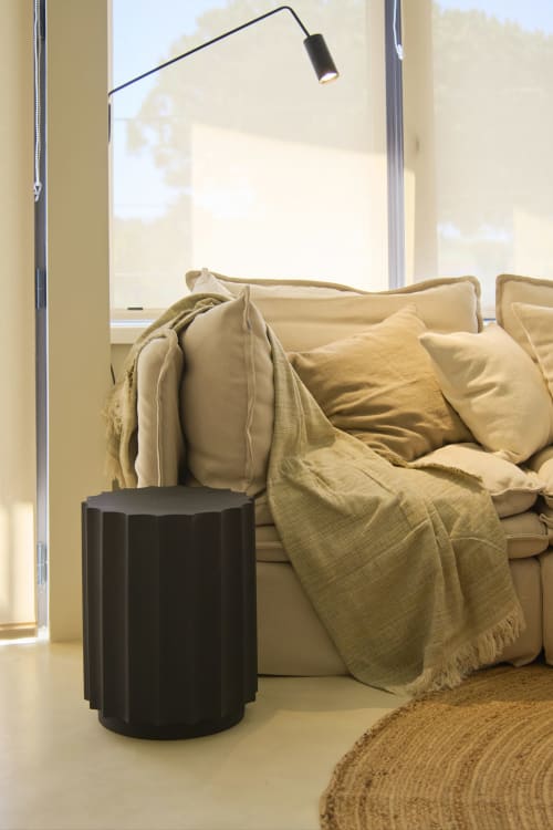 Cozy living area at Casa Redonda with beige sofa, mustard throw blanket, black side table, and arc lamp overlooking pool view