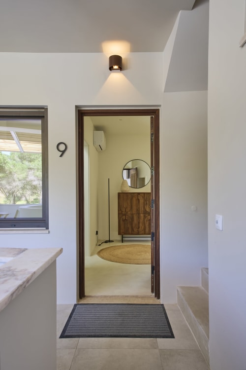 Casa Redonda 9 entrance with wooden door, white walls, and modern lighting at Casa Redonda by Villas Aura in Aroeira,