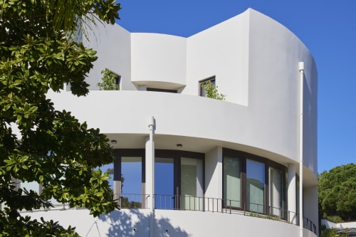 Modern white villa Casa Redonda at Villas Aura in Aroeira with curved architecture, large windows, and pool views