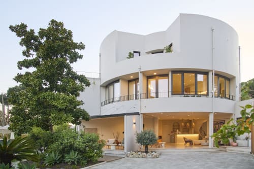 Modern white villa Casa Redonda at Aroeira with curved architecture, pool view, and lush gardens