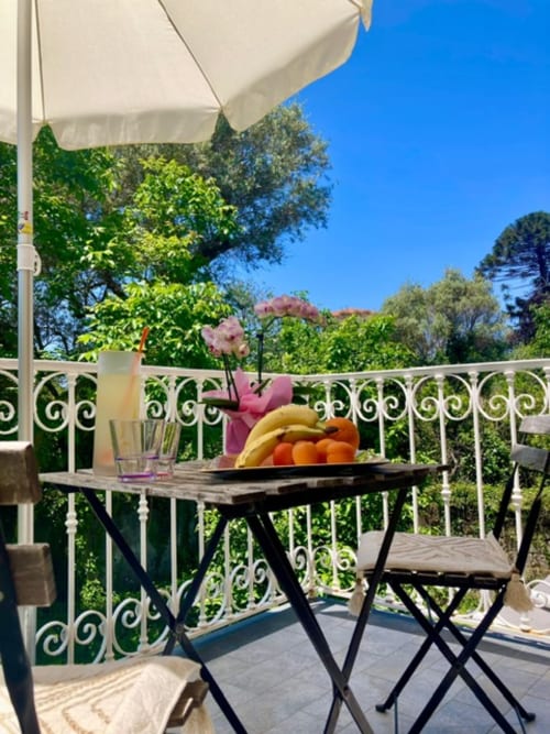 Terrazza giardino di Crawford Home Sant'Agnello con tavolo, fruttiera e vista sulle montagne sotto ombrellone