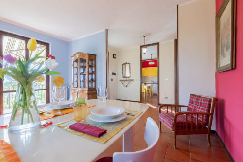 Sala da pranzo Prince Garda a Salò con pareti colorate, fiori freschi e tavola elegantemente apparecchiata