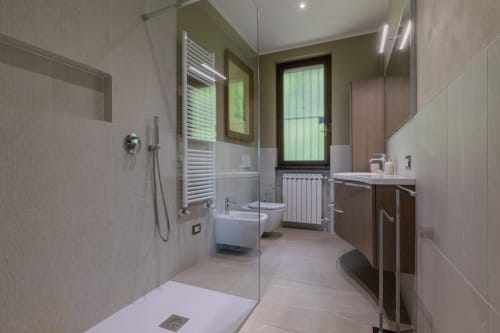 Bagno moderno dell'hotel Prince Garda a Salò con doccia a filo pavimento, toilet, bidet e scaldasalviette elettrico