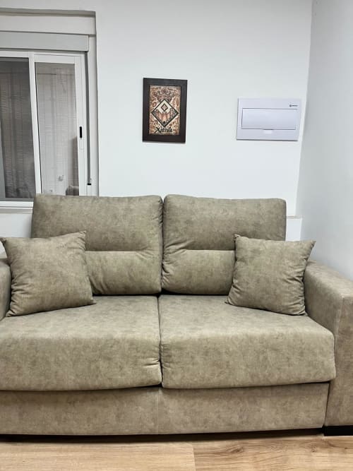 Sofá seccional color beige con cojines en la sala de estar del apartamento Casa Portalet, Xativa