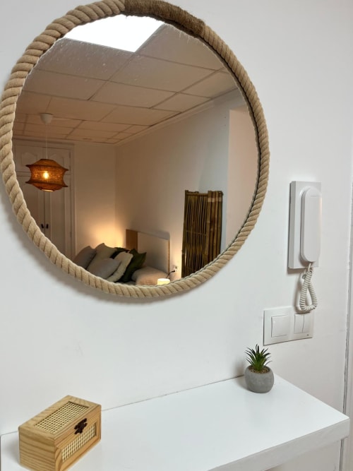 Espejo de baño con marco de cuerda en apartamento Casa Portalet, Xátiva, con tocador blanco y planta en maceta