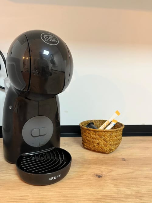 Cafetera Nescafé Dolce Gusto con accesorios sobre mesada de madera en apartamento Casa Portalet, Xátiva