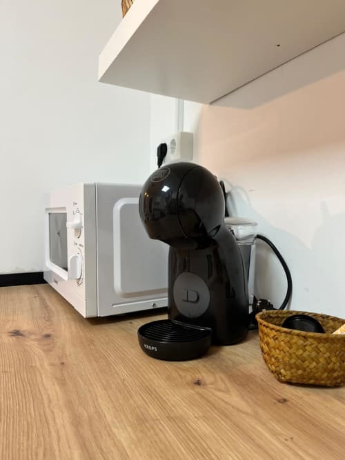 Cafetera Krups negra y microondas en la cocina del apartamento Casa Portalet, Xátiva