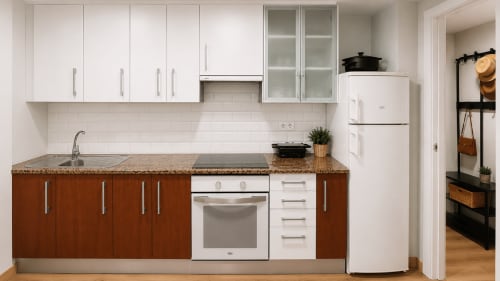 Cocina moderna del apartamento de Baiona con armarios marrones, encimeras blancas, electrodomésticos de acero inoxidable y encimera de granito