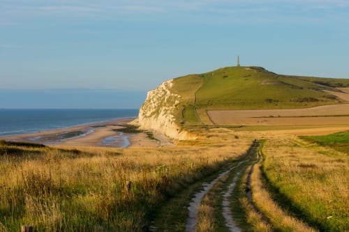 Falaises de craie côtières avec colline verdoyante et plage de sable fin près des Logis d'Emma, France