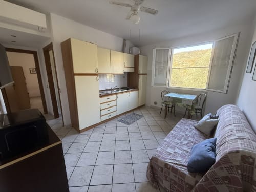 Bilocale con angolo cucina, letto e ampia finestra presso l'Agriturismo Gli Ulivi a Maremo Sottano