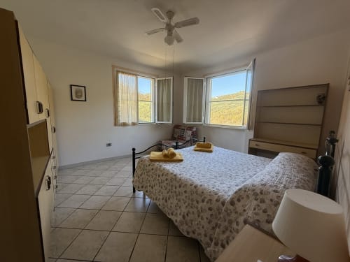 Spaziosa camera bilocale all'Agriturismo Gli Ulivi con letto matrimoniale, ventilatore a soffitto e vista montagna dalle finestre