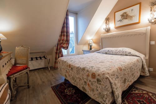 Hôtel des Bains Chambre Classique with floral bedding, sloped ceiling, wooden floors, and traditional furnishings