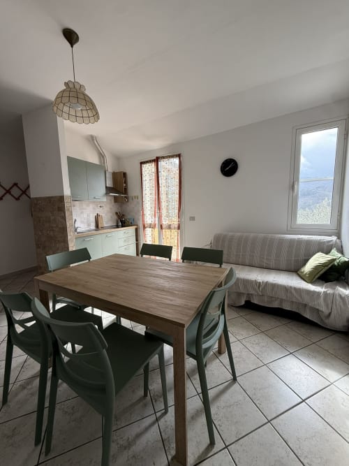 Open-plan kitchen and living area in 2-bedroom apartment at Agriturismo Gli Ulivi, Maremo with dining table and sofa
