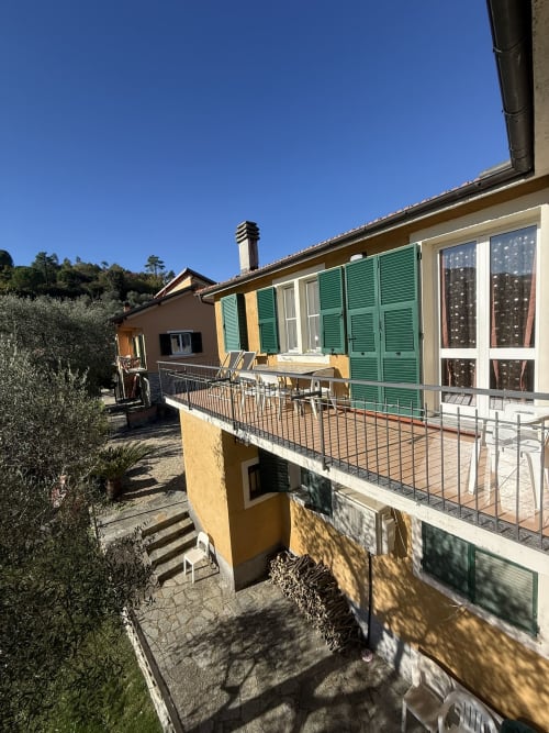 Agriturismo Gli Ulivi apartment exterior with green shutters, terrace, and olive trees in Maremo, Italy