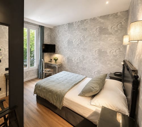 Chambre Deluxe de l'Hôtel des Bains avec vue jardin, décoration contemporaine, papier peint beige à motifs et parquet