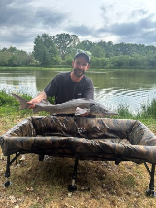 Angler displays catch by river at Les 5 Etangs, Brinon-sur-Sauldre fishing retreat