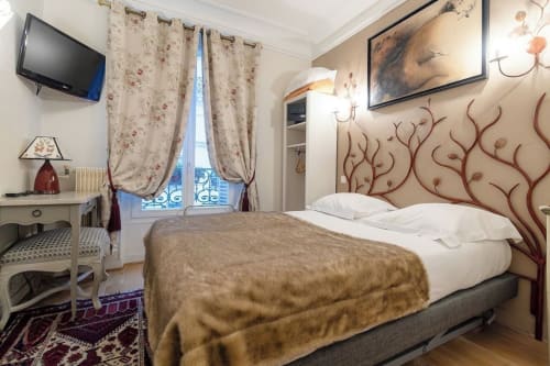 Hôtel des Bains Classic room with double bed, floral curtains, city view, and decorative wall art