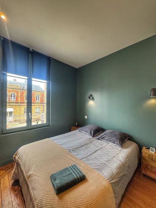 Chambre moderne de l'hôtel O LIT à Trouville-sur-Mer avec murs vert sauge, lit double, parquet et fenêtre donnant sur la vue