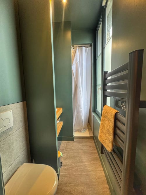Salle de bain moderne de l'appartement O LIT studio, Trouville-sur-Mer, avec sèche-serviettes chauffant, douche et toilettes