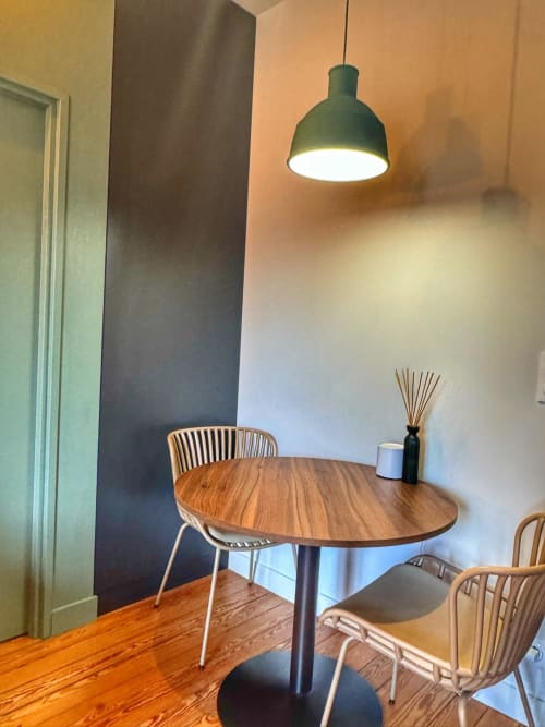 Coin repas moderne du studio O LIT, Trouville-sur-Mer, avec table ronde en bois, chaises contemporaines et détails verts