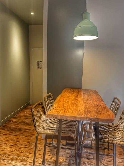 Salle à manger moderne du studio O LIT à Trouville-sur-Mer, table en bois, chaises tressées, suspension vert menthe