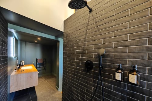 Salle de bain moderne du O LIT Duplex à Trouville-sur-Mer avec murs en brique, pommeau de douche pluie et équipements contemporains