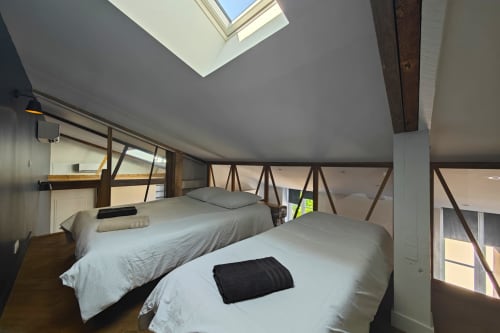 Chambre duplex à l'hôtel O LIT à Trouville-sur-Mer avec deux lits, lucarne et poutres apparentes