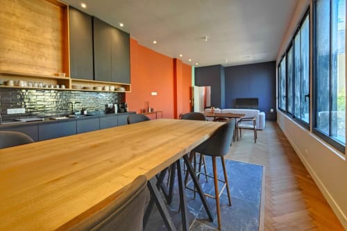 Appartement loft moderne à O LIT Trouville-sur-Mer avec cuisine ouverte, table à manger en bois et séjour bleu