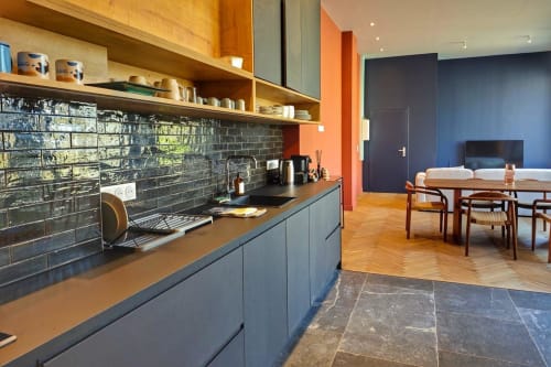Cuisine loft moderne et coin repas à l'hôtel O LIT à Trouville-sur-Mer avec crédence en carrelage noir, étagères en bois