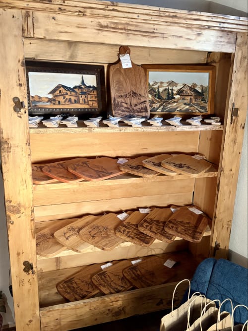 Vitrine en bois à La Ferme 1828 B&B à Megève avec paysages montagneux sculptés et objets décoratifs en bois
