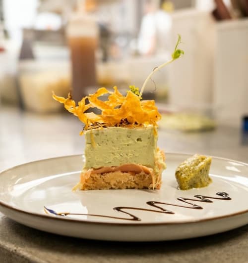 Dessert élégamment dressé à l'hôtel La Verriaire : gâteau feuilleté, mousse verte et feuille d'or