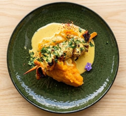 Noix de Saint-Jacques poêlée, sauce et herbes sur assiette verte à La Verriaire, Chanverrie