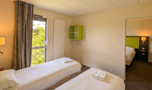 Chambre twin de l'hôtel La Verriaire à La Verrie, France, avec rangement vert et vue sur la terrasse