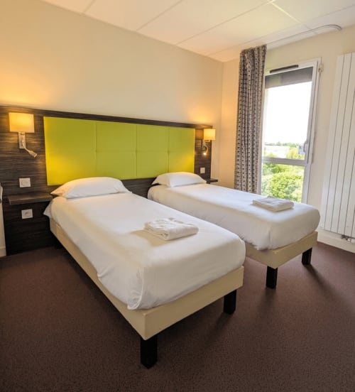 Chambre twin de l'hôtel La Verriaire à La Verrie avec tête de lit vert citron et vue sur la campagne