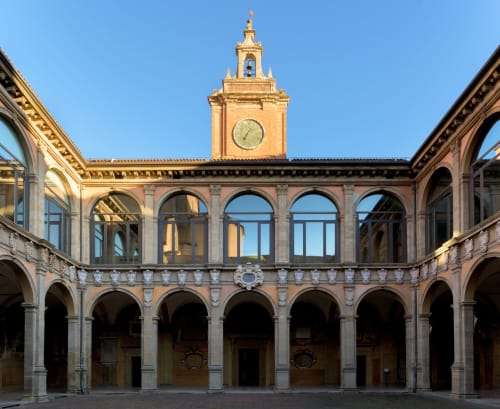 Suggestivo cortile storico di BnB Fantasia a Bologna con colonnati ad arco e torre dell'orologio