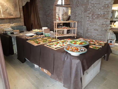 Buffet catering presso Mappamondi B&B Venezia con insalate, piatti e antipasti su tovaglia scura