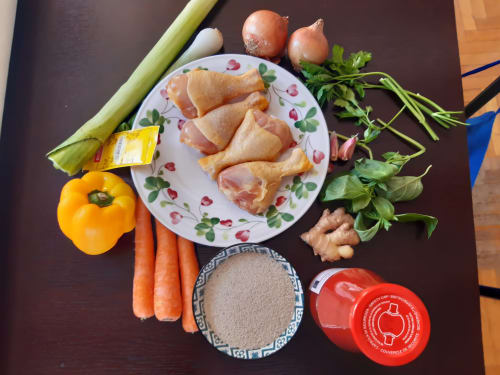 Ingredienti per la cucina al Mappamondi B&B Venezia: pollo, verdure, erbe aromatiche, spezie e condimenti su tavolo scuro.