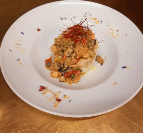 Piatto raffinato al Mappamondi B&B Venezia con filamenti di zafferano, verdure e fiori edibili