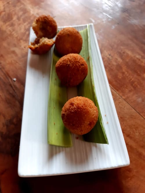 Arancini dorati fritti su foglia di banana verde, antipasto della struttura ricettiva Mappamondi Venice