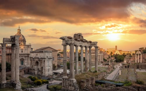 Rovine del Foro Romano al tramonto con antiche colonne e templi, vicino al Colosseo Esclusiva Permanenza a Roma